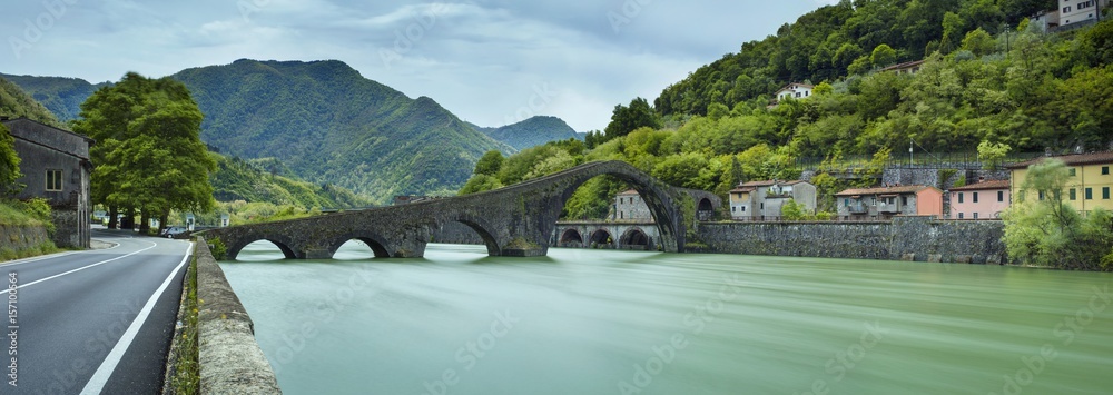 panorama with bridge and green river in Italy