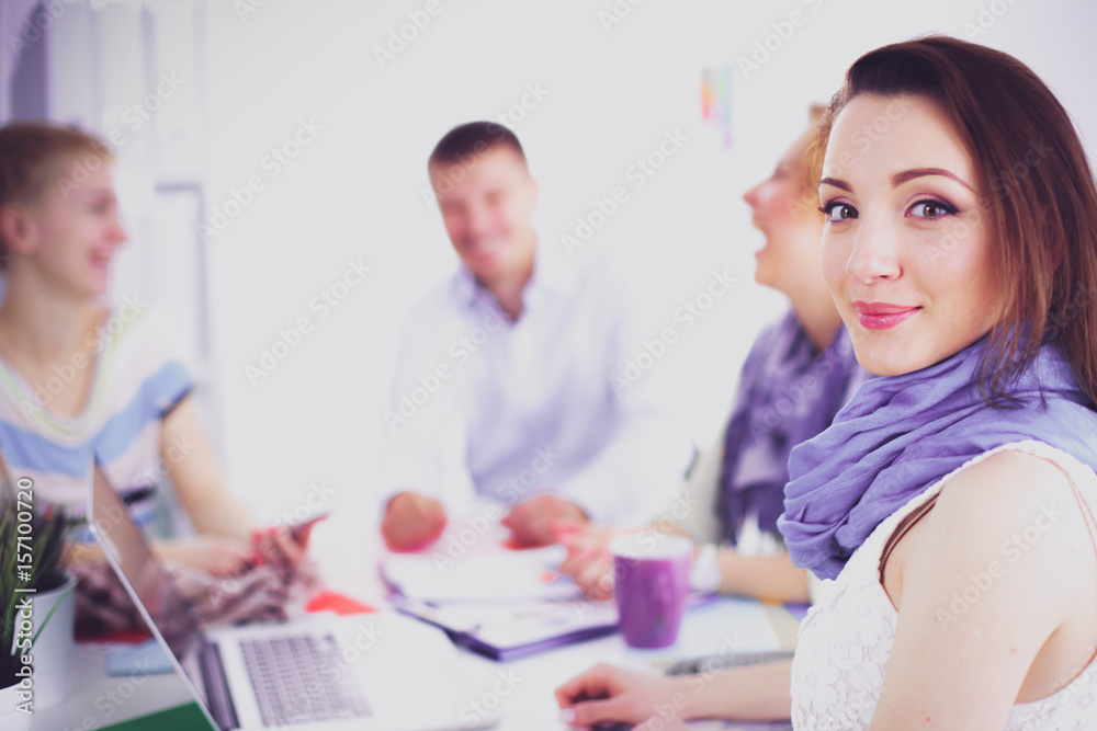 Portrait of attractive female designer sitting on desk in office Portrait of attractive female designer sitting on desk in office