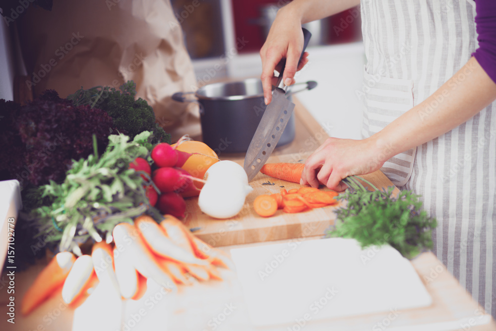 Young woman cutting vegetables in the kitchen Young woman cutting vegetables in the kitchen