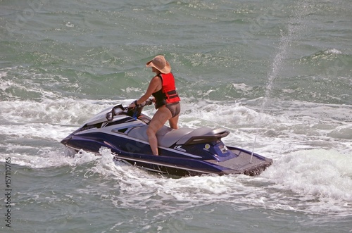 Middle aged woman running waves on a jet ski on the florida intra-coastal waterway off Miami Beach