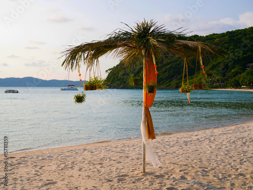 Beach umbrella exotic decoration with coconut tree, sea view and island resort