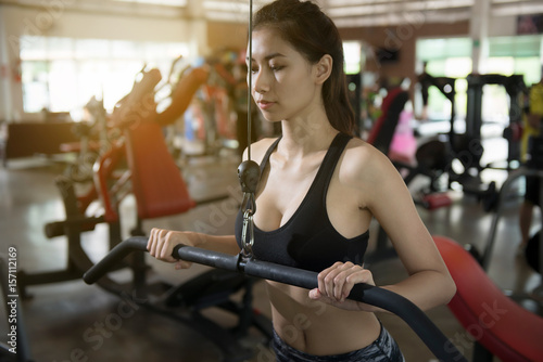 Photography Young asian woman in sportswear on the simulator at gym workout.