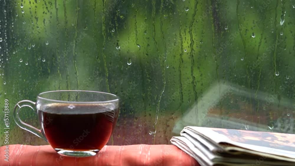 Steaming coffee cup on a rainy day window background