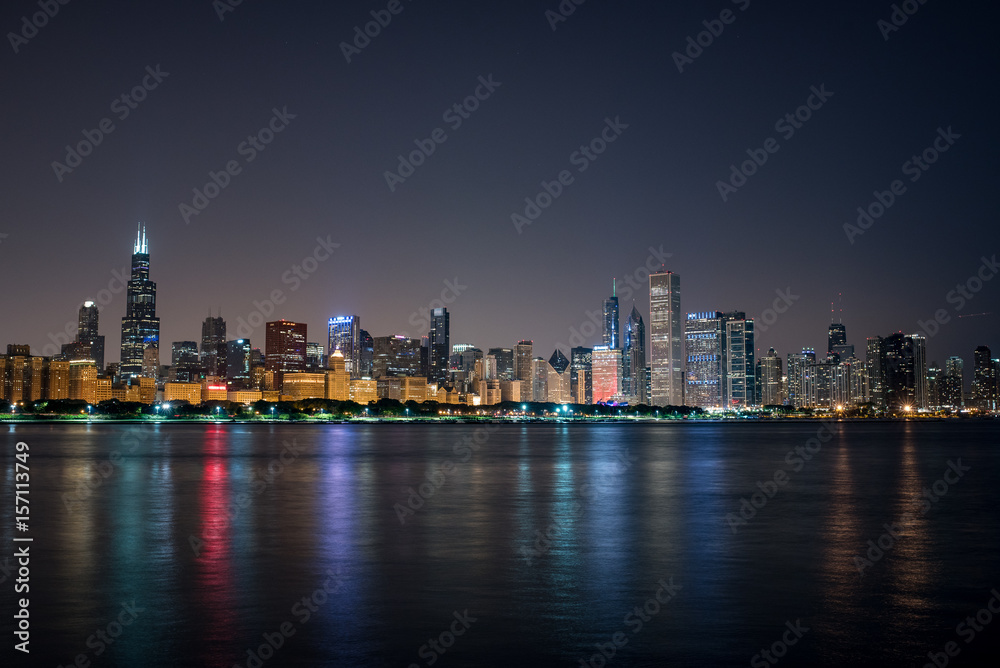 Nightime Skyline of Chicago, a haze behind the bright city lights and the colorful reflections in the water