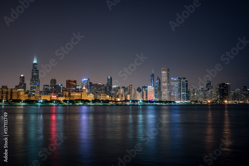 Nightime Skyline of Chicago, a haze behind the bright city lights and the colorful reflections in the water