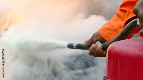 Firefighter putting out a fire with a powder type extinguisher..