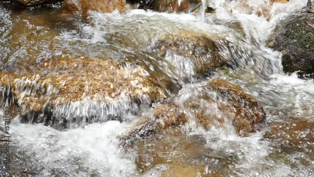 Slow motion rushing waterfall in the mountains with tropical forest. Beautiful nature background. 