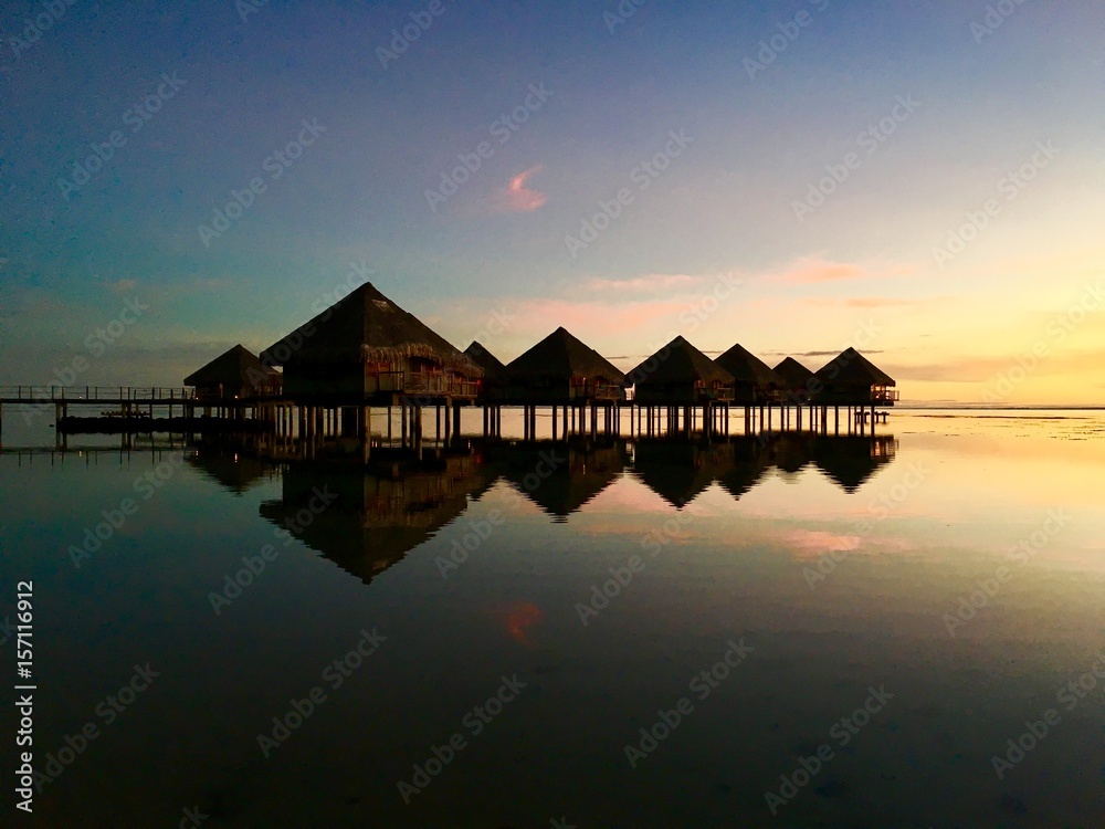 Beautiful view on Moorea and the overwater bungalows of a luxury resort during sunset at the beach of Punaauia