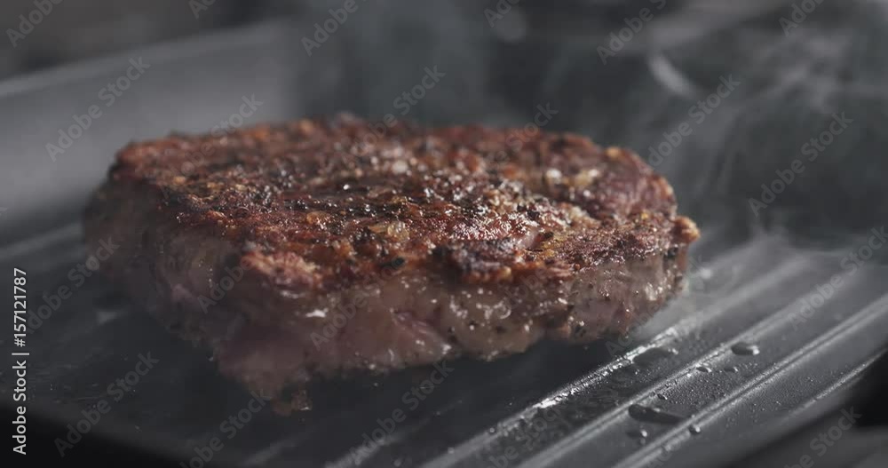 Slide slow motion shot of cooking rib eye steak on grill pan, 4k 60fps prores footage Slide slow motion shot of cooking rib eye steak on grill pan, 4k 60fps prores footage