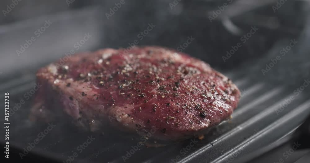 Slide slow motion shot of cooking rib eye steak on grill pan, 4k 60fps prores footage Slide slow motion shot of cooking rib eye steak on grill pan, 4k 60fps prores footage
