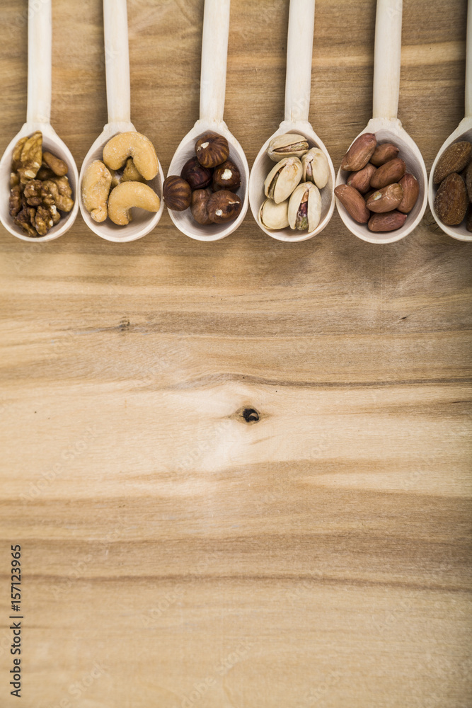 Nuts in a wooden spoons on a wooden table. Nuts in a wooden spoons on a wooden table.
