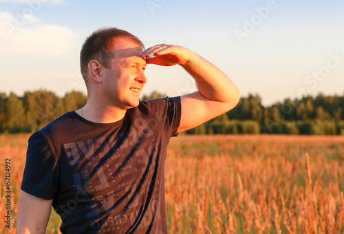 man looking into distance on field