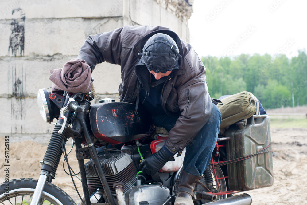 A post apocalyptic man on motorcycle near the destroyed building A post apocalyptic man on motorcycle near the destroyed building