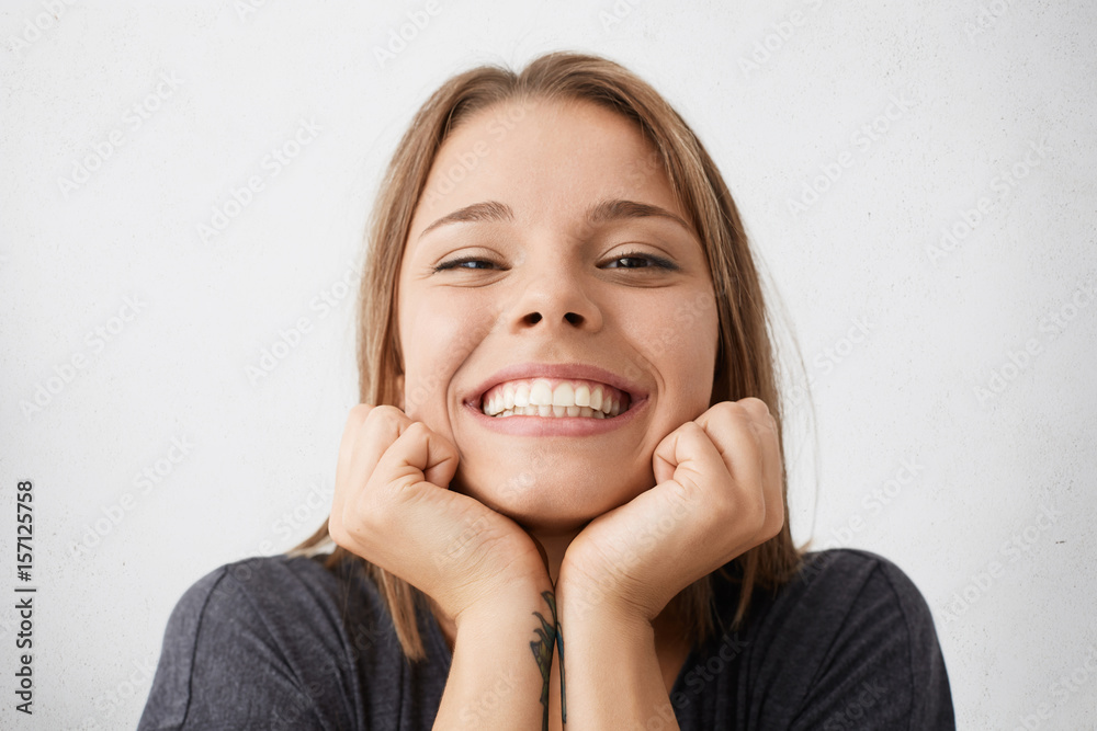 Φωτογραφία Close up indoor portrait of happy excited young female celebrating success and p