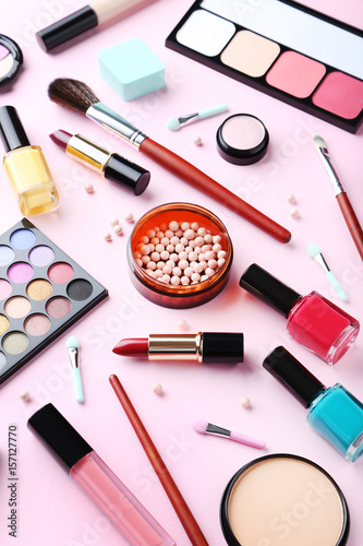 Different makeup cosmetics on a pink background