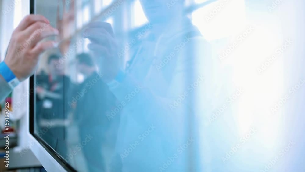The man uses a large touch screen