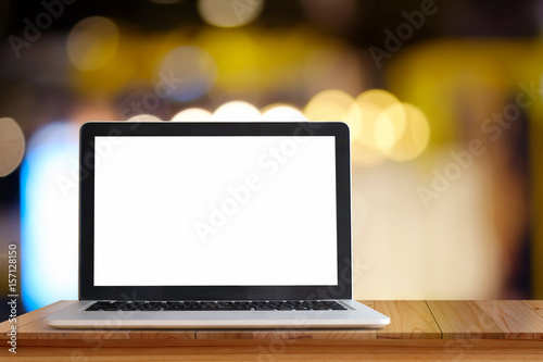 Laptop onwood table and blur city night background. For Graphic display montage Concept.