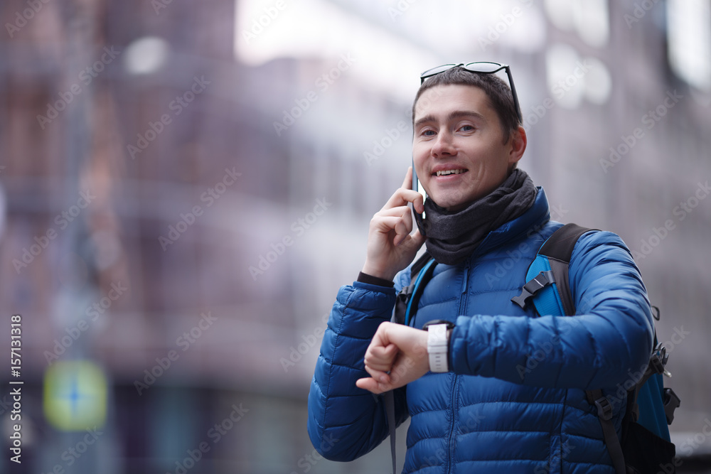 Man talking on phone and looking at smartwatch Man talking on phone and looking at smartwatch