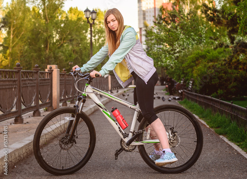 Portrait of young beautiful blonde girl with  bicycle