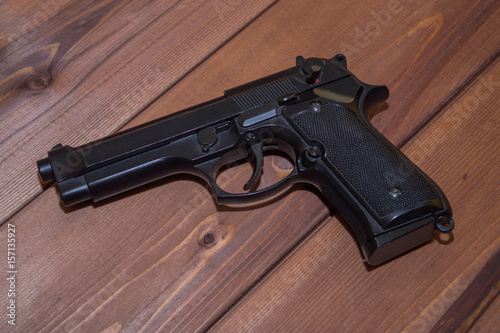 Black pistol on a wooden background