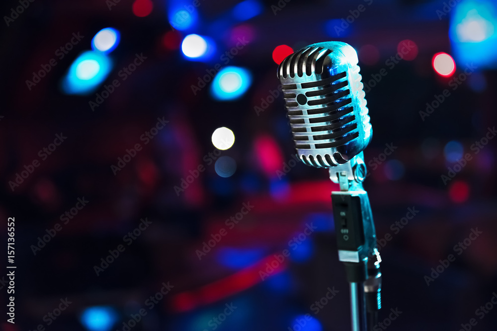 Naklejka premium Retro microphone against blur colorful light background