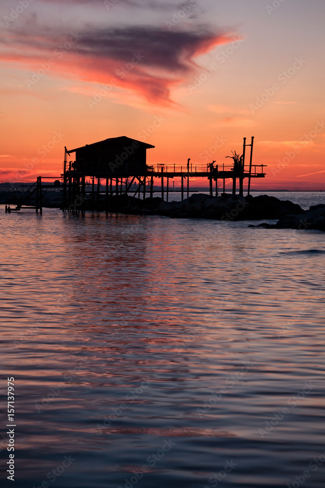 Stilt house in silhouette over the sea Stilt house in silhouette over the sea