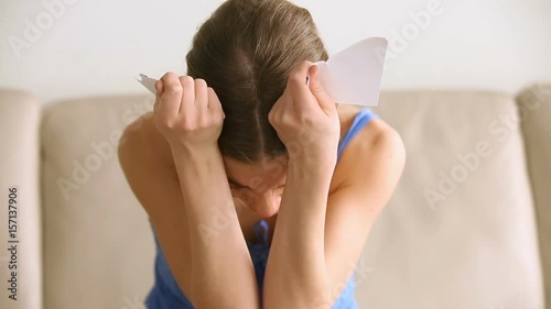 Upset desperate woman crying at home, attractive betrayed girlfriend tearing photo with ex, feeling hopeless after breaking up with unfaithful boyfriend, broken hearted wife starting new life