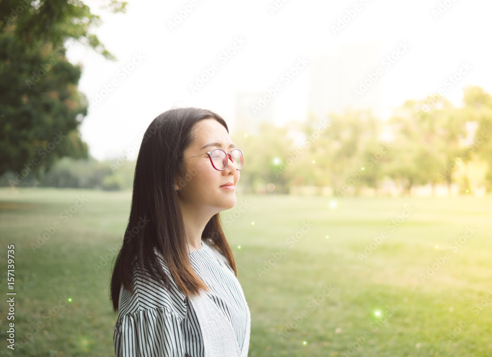 smile relaxing in the park by asian woman, enjoying sunrise in the morning smile relaxing in the park by asian woman, enjoying sunrise in the morning