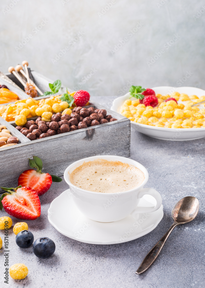 Healthy breakfast with coffee, variety of cold quick cereals and berries in old gray wooden box, selective focus. Healthy breakfast with coffee, variety of cold quick cereals and berries in old gray wooden box, selective focus.