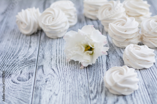 White zephyr and white flower on grey wooden background