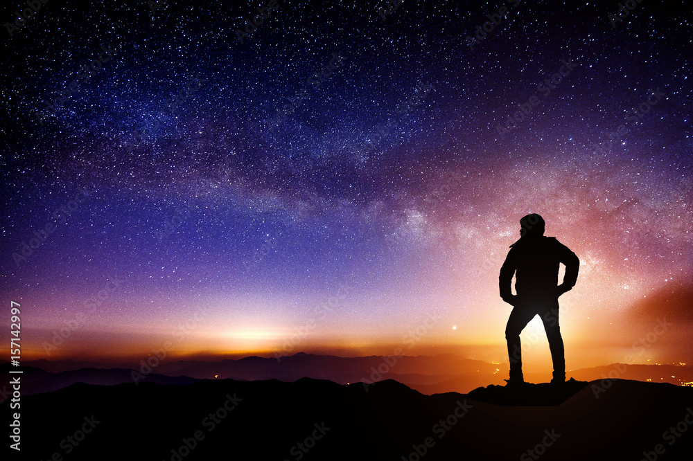Silhouette a person is standing on mountains with Milky Way galaxy.