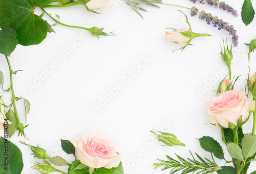 Garden fresh flowers and leaves flat lay frame on white background