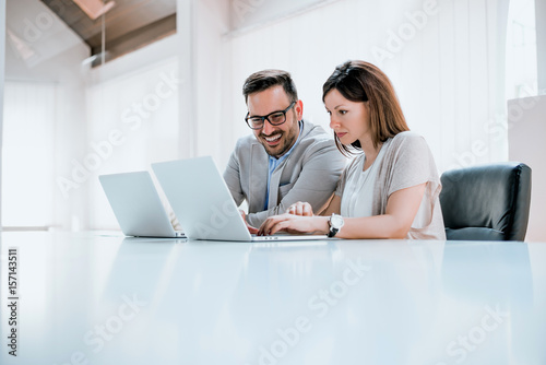 Two entrepreneurs sitting together working in an office desk