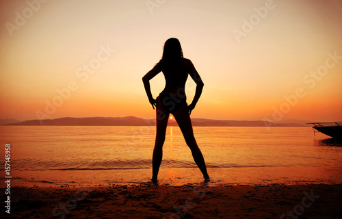 Schöne Frau am Strand betrachtet Sonnenuntergang 