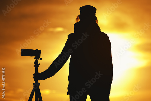 Silhouette of Female photographer against sunset