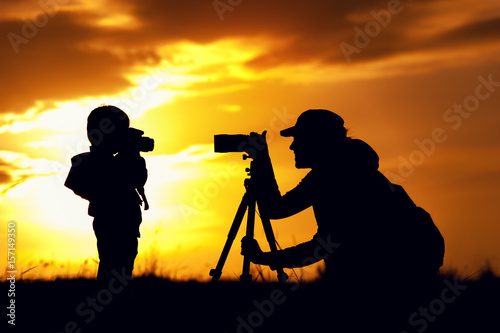 Silhouettes of mother and child taking pictures