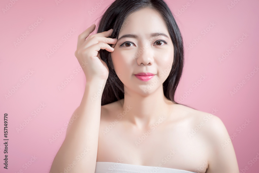 Long hair asian young beautiful woman cross arm and point finger upward isolated over pink background. natural makeup, SPA therapy, skincare, cosmetology and plastic surgery concept. Long hair asian young beautiful woman cross arm and point finger upward isolated over pink background. natural makeup, SPA therapy, skincare, cosmetology and plastic surgery concept.