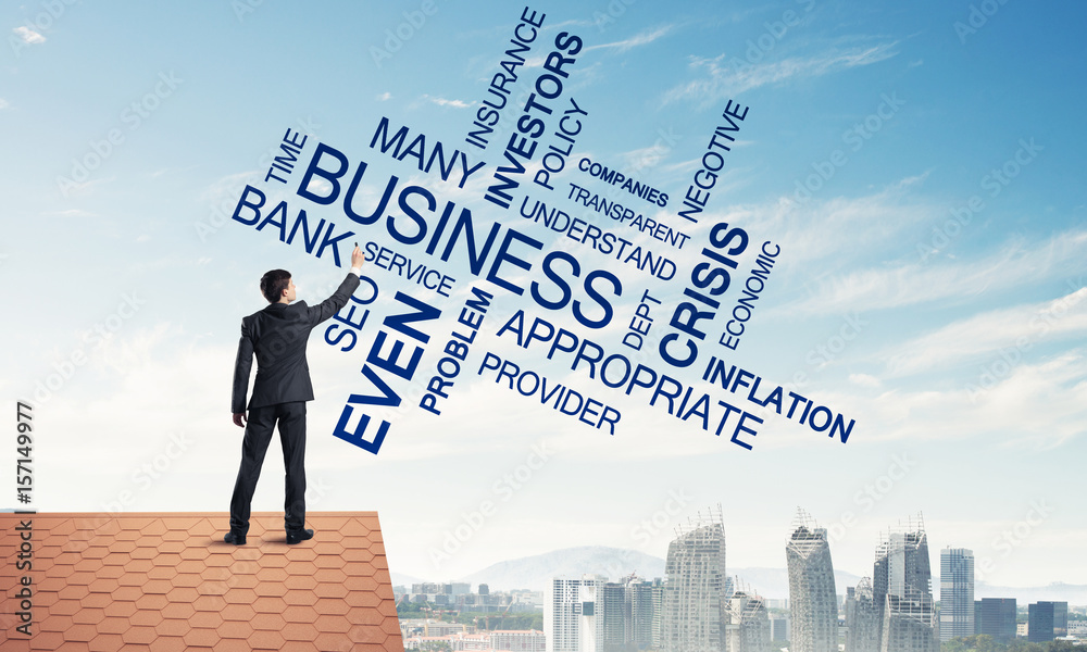 Young businessman standing on house roof and writing leadership Young businessman standing on house roof and writing leadership