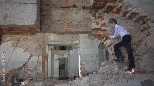Boy hides in a ruined building after the war, lost, fear, loneliness, threat, game