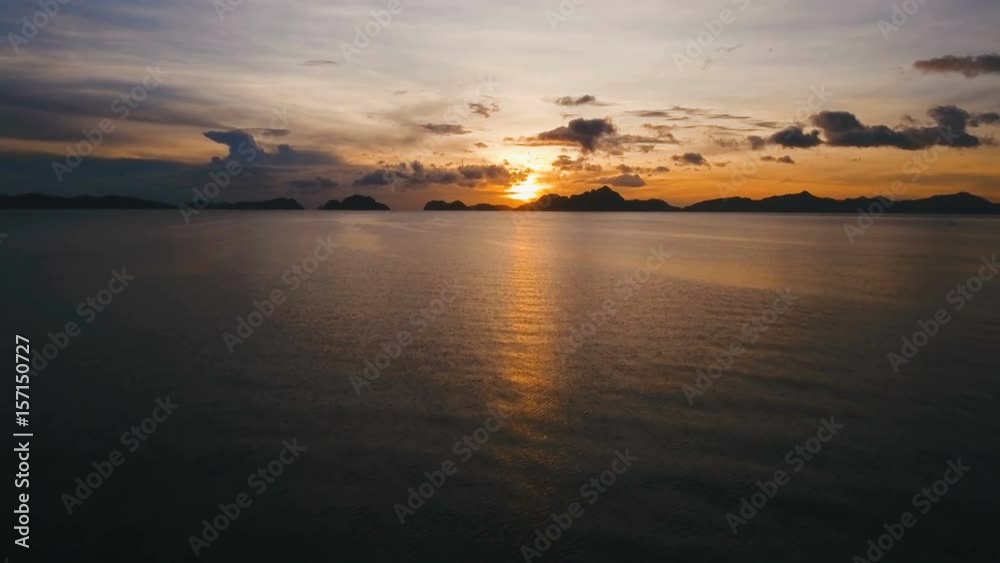 Marine tropical sunset over the sea. Aerial view: Sunset over the sea in the background orange sky and islands. Fly over the ocean in sunset time. Travel concept. Nothing but sky, clouds and water Marine tropical sunset over the sea. Aerial view: Sunset over the sea in the background orange sky and islands. Fly over the ocean in sunset time. Travel concept. Nothing but sky, clouds and water