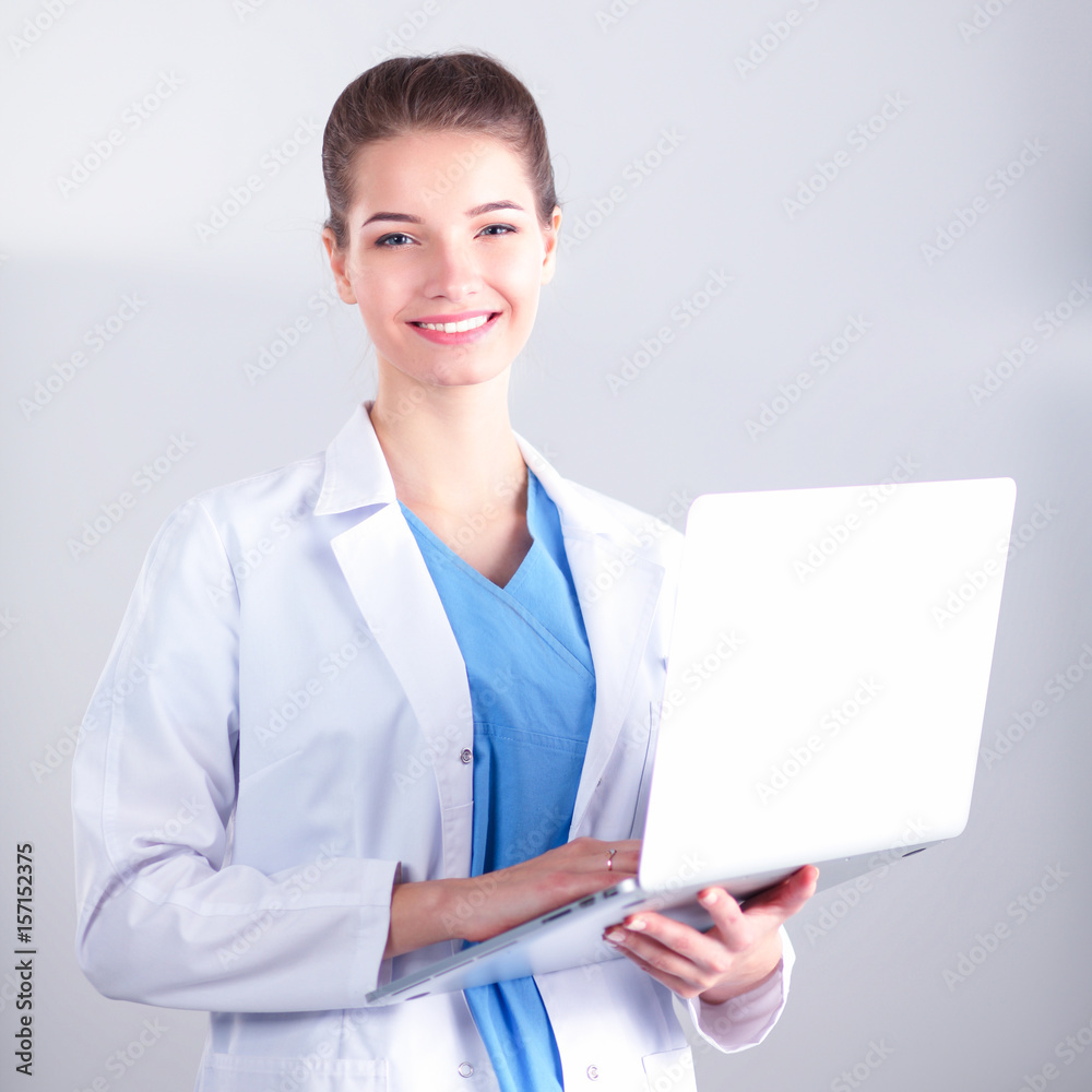 Beautiful woman doctor or nurse holding laptop computer isolated on a white background Beautiful woman doctor or nurse holding laptop computer isolated on a white background