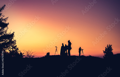 Silhouettes of unidentified photographers on the mountain peak in the morning