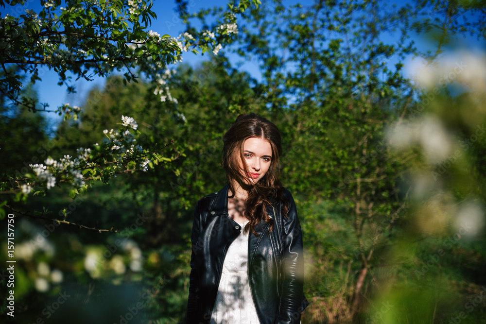 outdoor portrait of a beautiful brunette woman in white dress among blossom apple trees outdoor portrait of a beautiful brunette woman in white dress among blossom apple trees
