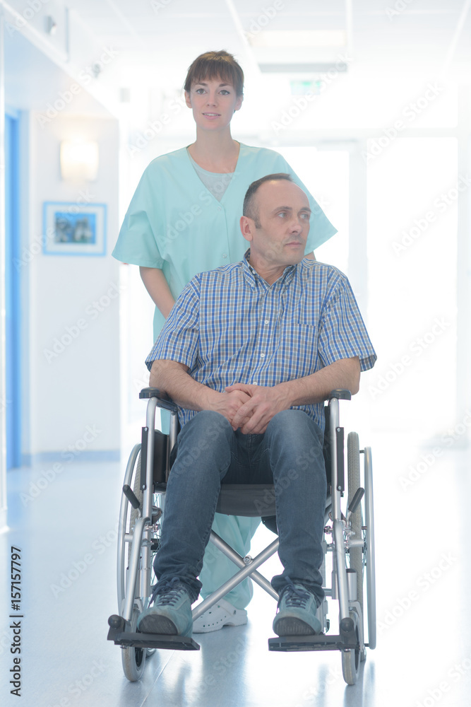 Nurse pushing patient in wheelchair Nurse pushing patient in wheelchair