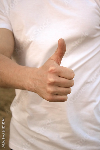 парень показывает положительный жест рукой, знак класс пальцем 