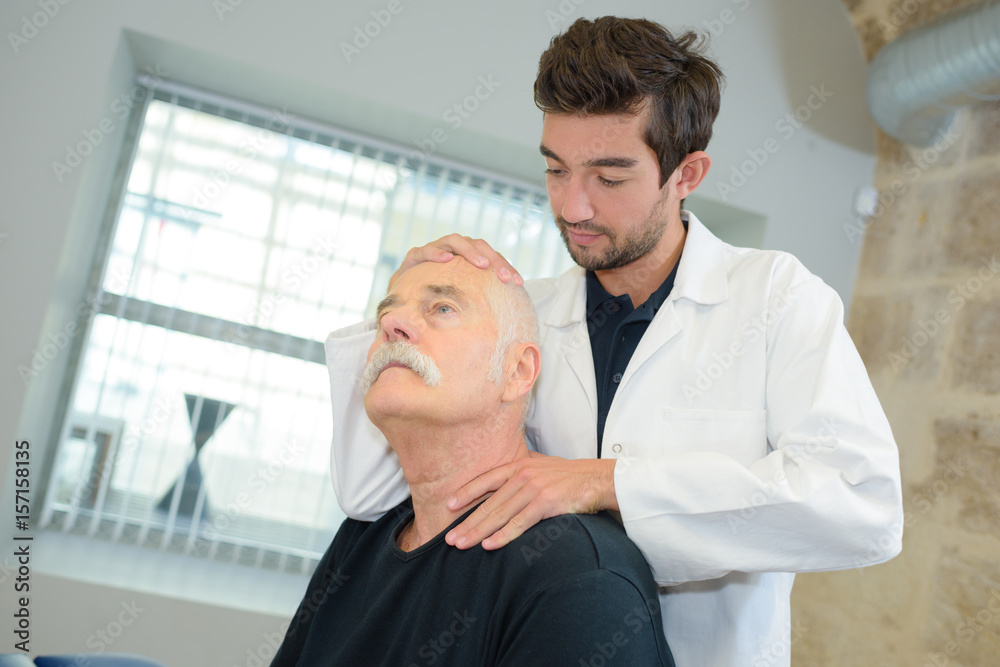 Obraz premium Chiropractor manipulating senior patient's neck