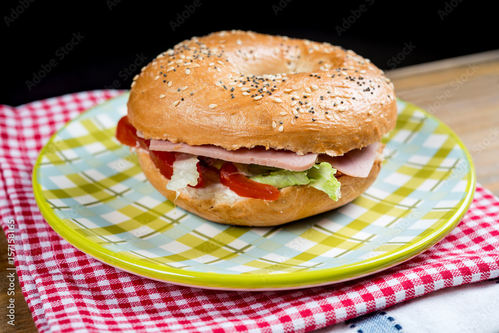 Bagel with fresh cheese and fresh lettuce on table Bagel with fresh cheese and fresh lettuce on table