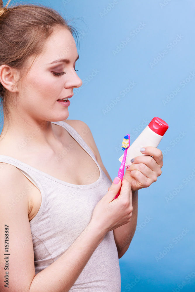 Woman holds toothbrush and paste for teeth cleaning