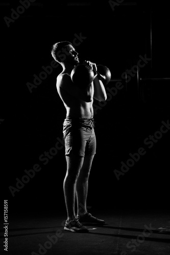 Fitness training. Man doing exercises with weights in dark gym. © Dmitry Tsvetkov