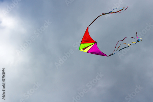 Fototapeta Naklejka Na Ścianę i Meble -  Flying kite on the cloudy blue sky background
